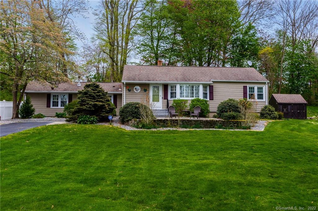 a front view of a house with a garden and plants
