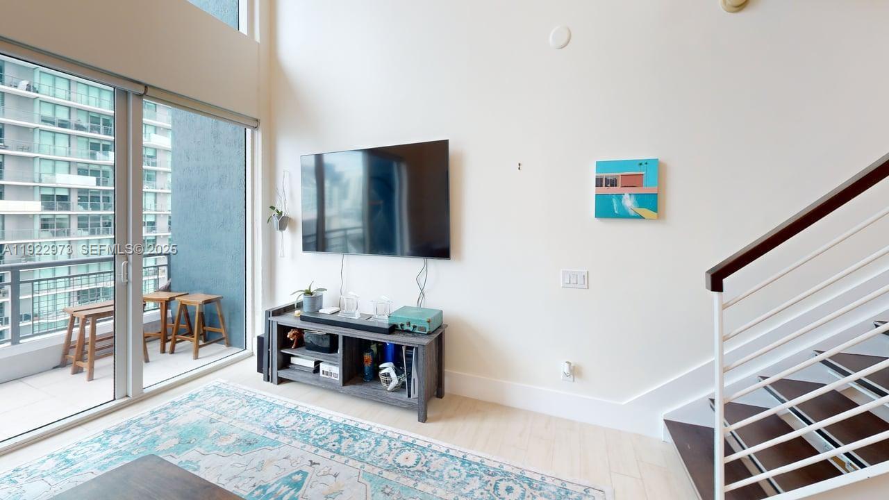 60 Southwest 13th Street, Unit 3620 Miami, FL 33130 - Photo 2 of 30 a living room with furniture and a flat screen tv
