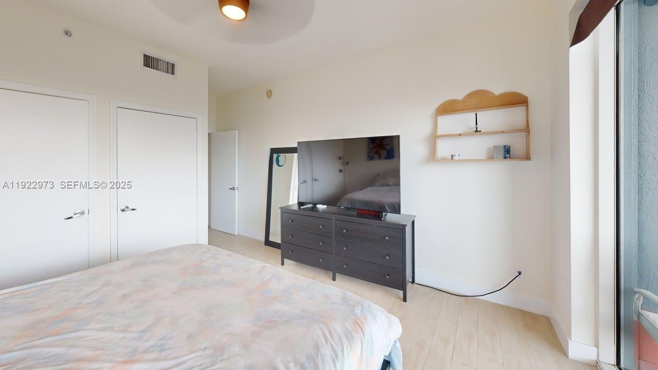 60 Southwest 13th Street, Unit 3620 Miami, FL 33130 - Photo 6 of 30 a bedroom with a bed and a painting on the wall