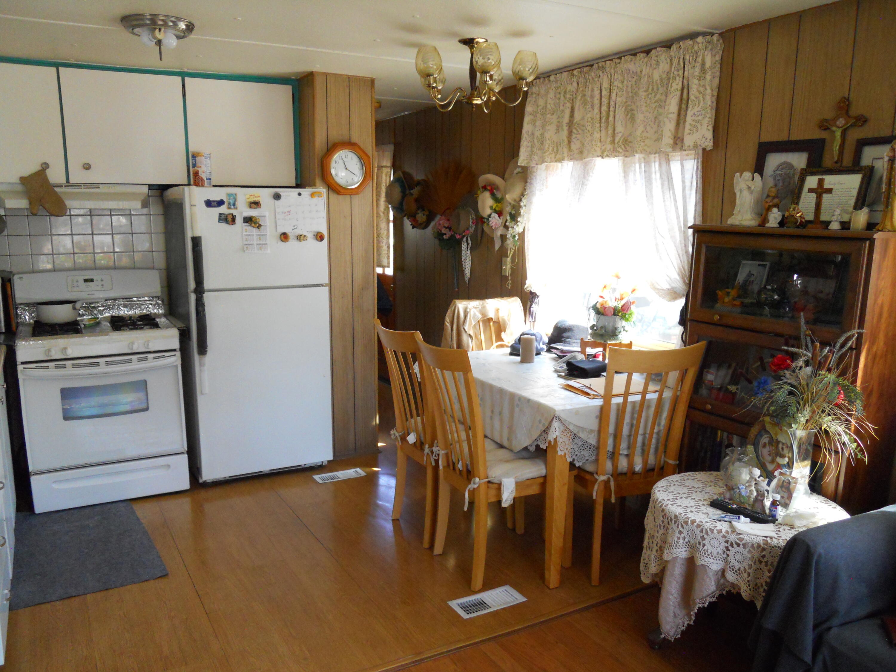520 Pine Avenue, Unit 33 Goleta, CA 93117 - Photo 8 of 16 a kitchen with stainless steel appliances a refrigerator a stove a dining table and chairs with wooden floor