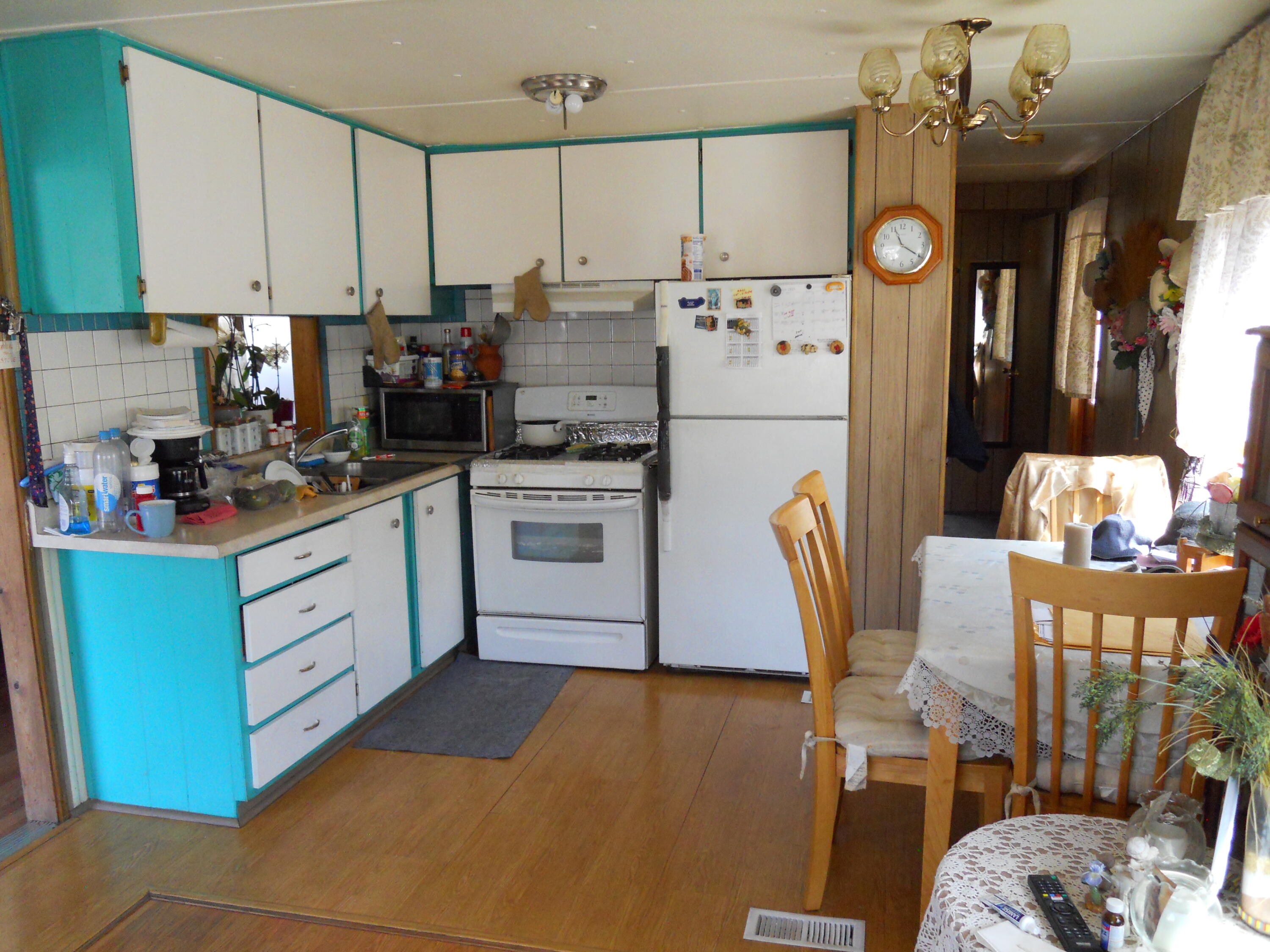 520 Pine Avenue, Unit 33 Goleta, CA 93117 - Photo 9 of 16 a kitchen with stainless steel appliances a stove top oven a refrigerator a dining table and chairs with wooden floor
