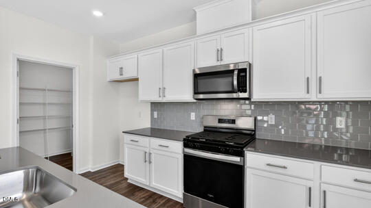 824 Comice Pear Way Willow Spring, NC 27592 - Photo 11 of 43 a kitchen with stainless steel appliances granite countertop a sink and a stove