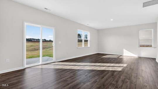 824 Comice Pear Way Willow Spring, NC 27592 - Photo 16 of 43 an empty room with wooden floor and windows