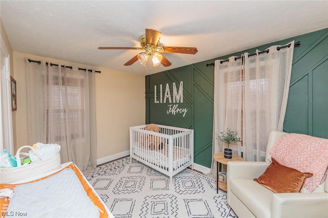 2199 Cranston Road Cleveland, OH 44118 - Photo 24 of 40 Bedroom with a nursery area, a textured ceiling, and ceiling fan