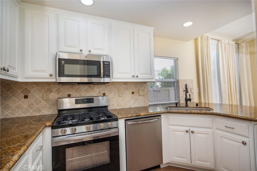 1 Quebec Aliso Viejo, CA 92656 - Photo 9 of 40 a kitchen with granite countertop white cabinets and appliances