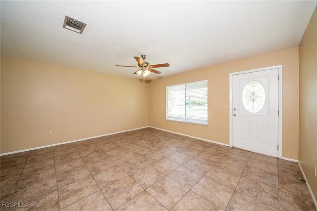 an empty room with windows and fan