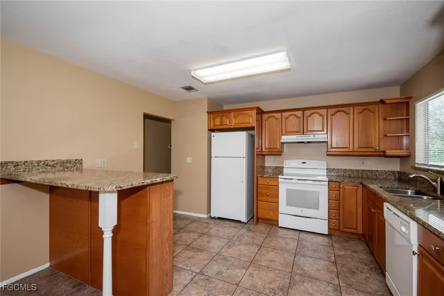 a kitchen with a sink stove and refrigerator
