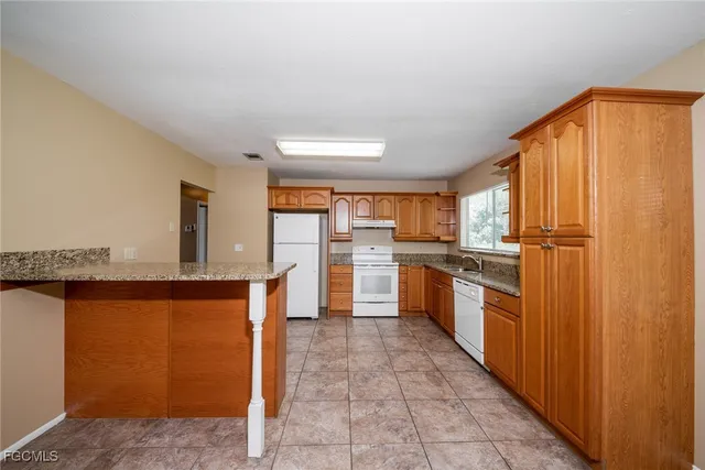 a kitchen with stainless steel appliances granite countertop a refrigerator and a stove top oven