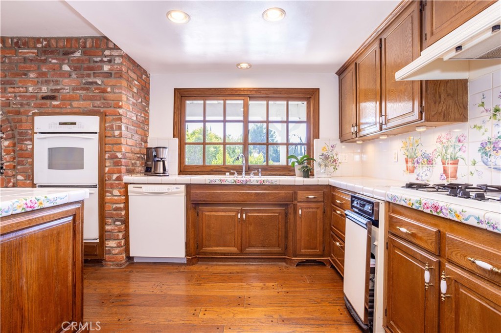 18924 Granada Circle Porter Ranch, CA 91326 - Photo 11 of 45 a kitchen with granite countertop a sink stove and cabinets