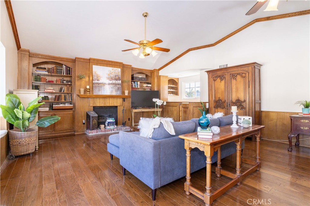 18924 Granada Circle Porter Ranch, CA 91326 - Photo 20 of 45 a living room with furniture a fireplace and a dining table with wooden floor