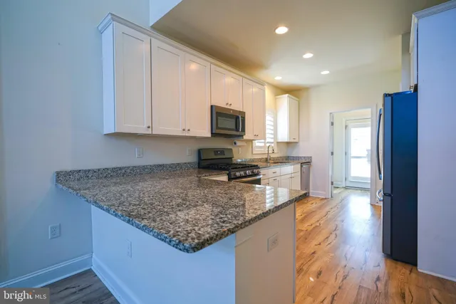 a kitchen with stainless steel appliances granite countertop a stove a sink and a microwave