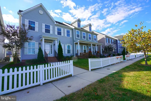 a view of a house with a yard and a large tree