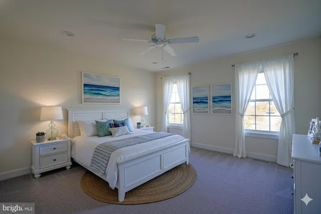 a bedroom with a bed couch and windows