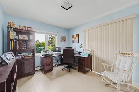 a view of a workspace with furniture and a window