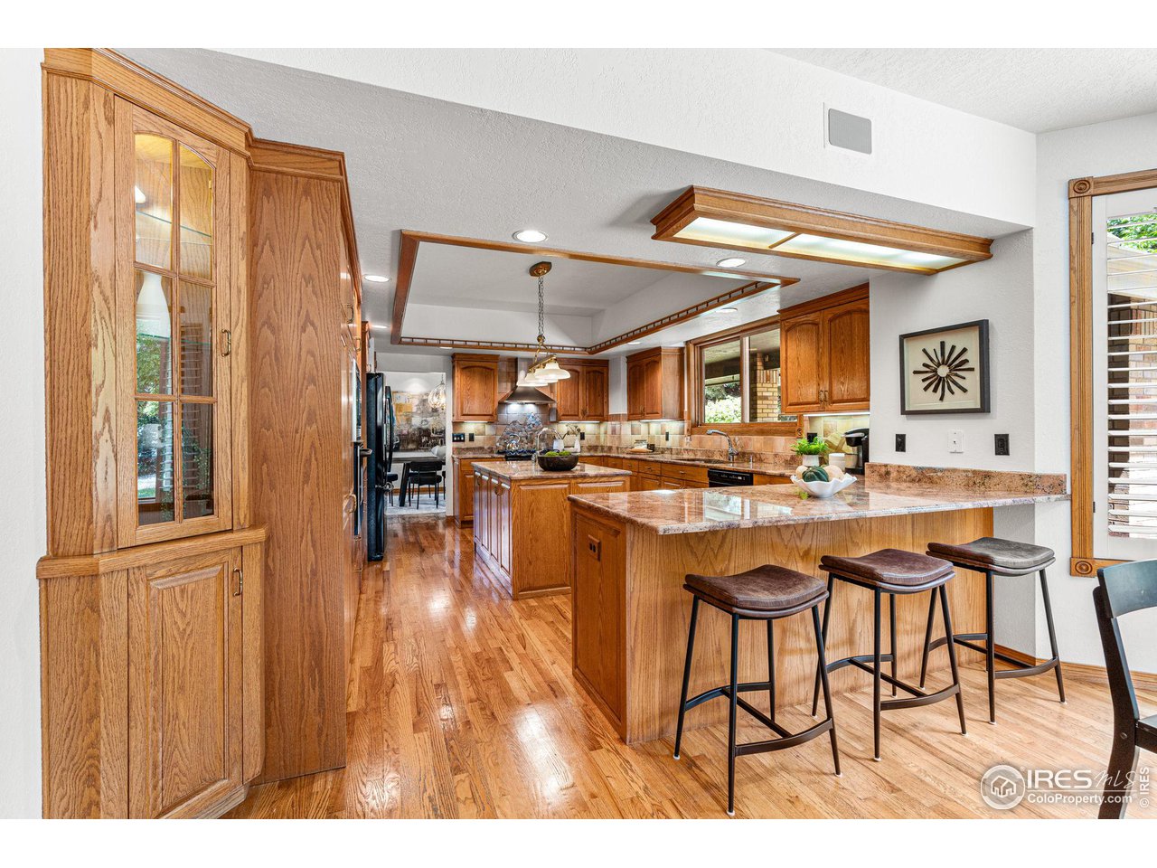 6968 Springhill Drive Niwot, CO 80503 - Photo 8 of 40 a kitchen with stainless steel appliances granite countertop a refrigerator a sink dishwasher and a dining table with wooden floor