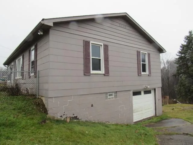 a view of backyard with barbeque grill and wooden fence