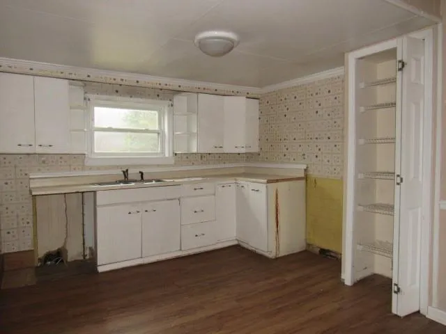 a kitchen with sink cabinets and wooden floor