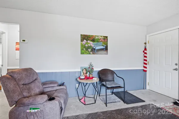a white kitchen with a stove a refrigerator and a dining table