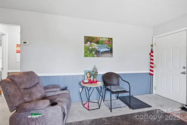 a white kitchen with a stove a refrigerator and a dining table