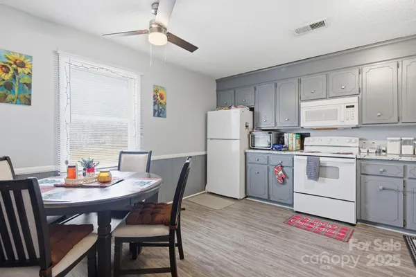 a kitchen with granite countertop cabinets and white appliances