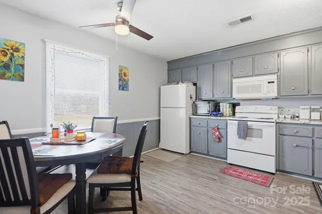 a kitchen with granite countertop cabinets and white appliances