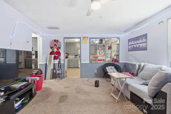 a living room with furniture a flat screen tv and a window