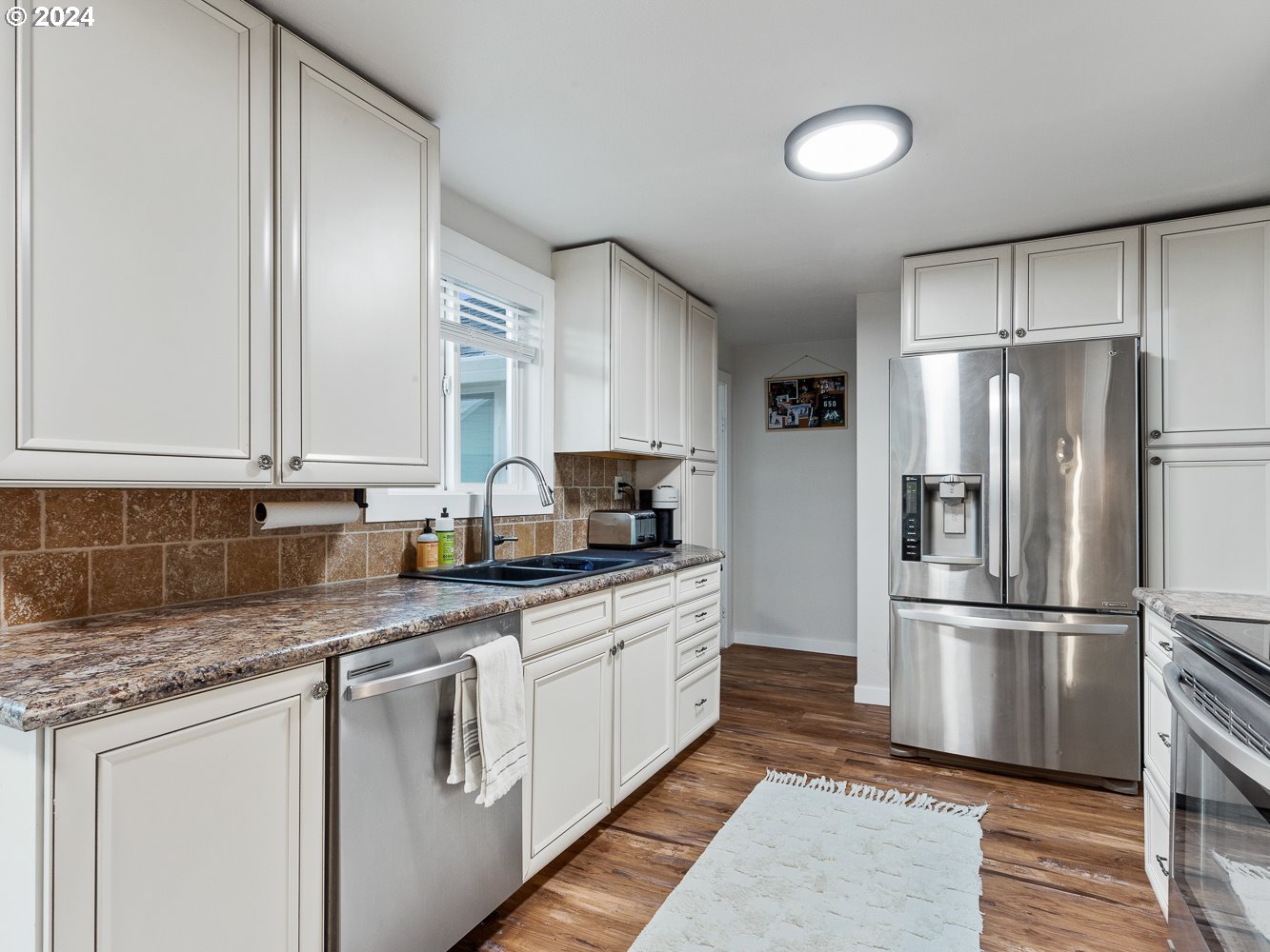 205 North 9th Avenue Ridgefield, WA 98642 - Photo 14 of 48 a kitchen with stainless steel appliances granite countertop a refrigerator sink and cabinets