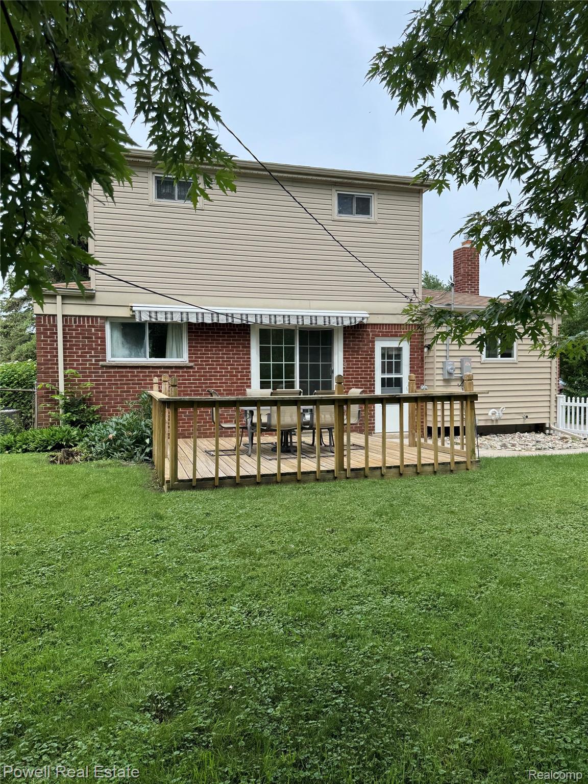 18166 Davidson Road Fraser, MI 48026 - Photo 21 of 27 wooden deck, a sliding glass door, and a retractable awning
