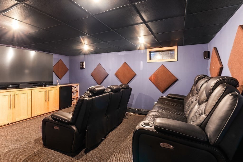 10 Stop River Road Norfolk, MA 02056 - Photo 20 of 29 a media room with lots of chairs and a projector screen