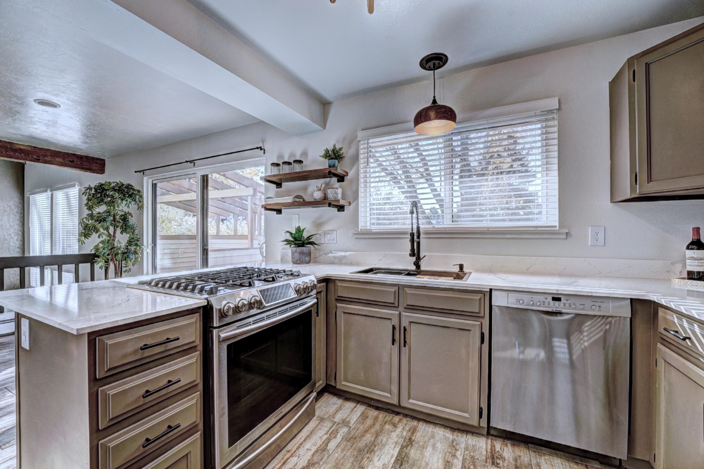 397 Ridge Cir Drive, Unit 8 Grand Junction, CO 81507 - Photo 6 of 40 a kitchen with stainless steel appliances granite countertop stove a sink and a microwave