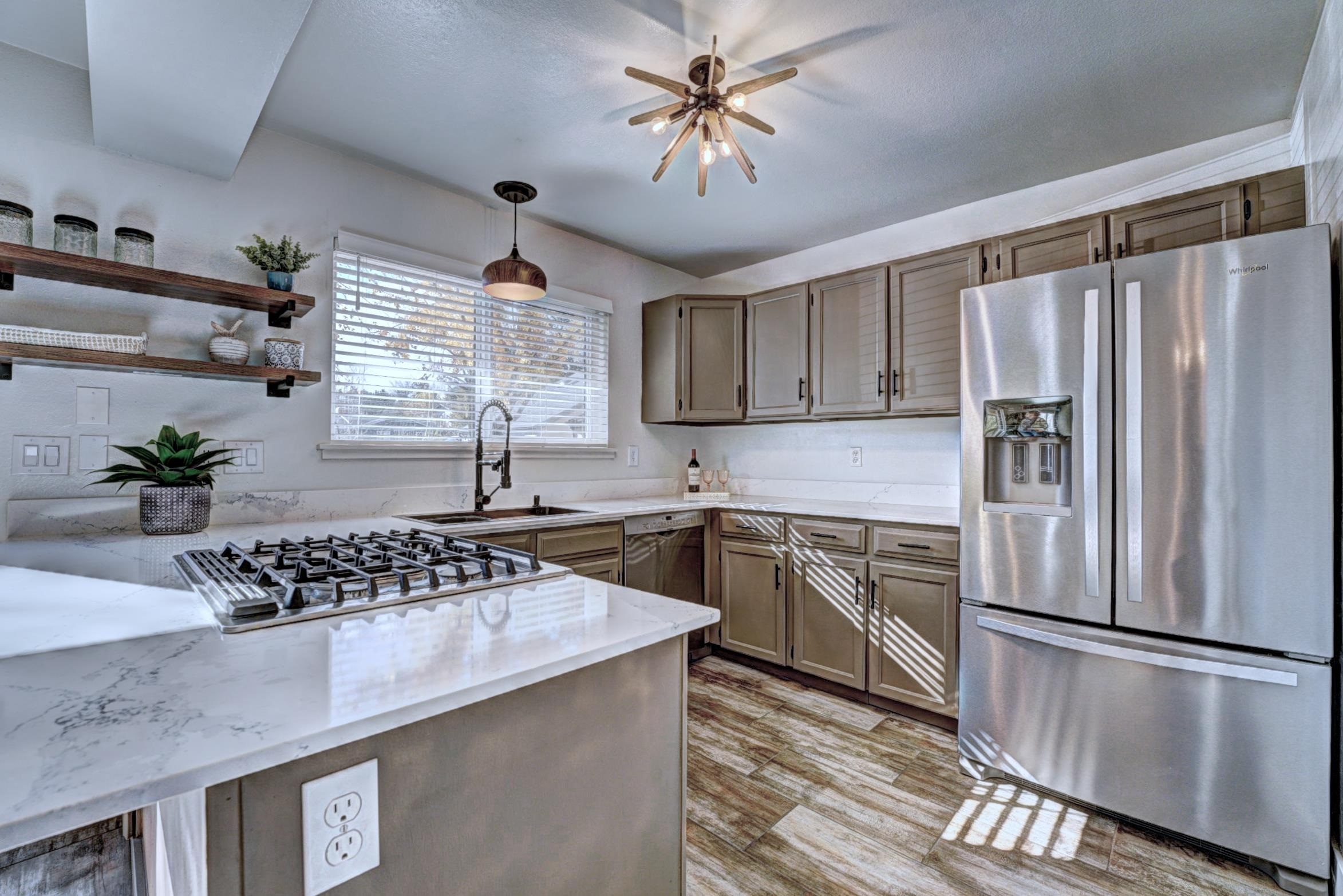 397 Ridge Cir Drive, Unit 8 Grand Junction, CO 81507 - Photo 7 of 40 a kitchen with stainless steel appliances granite countertop a refrigerator a sink dishwasher a stove and white countertops with wooden floor