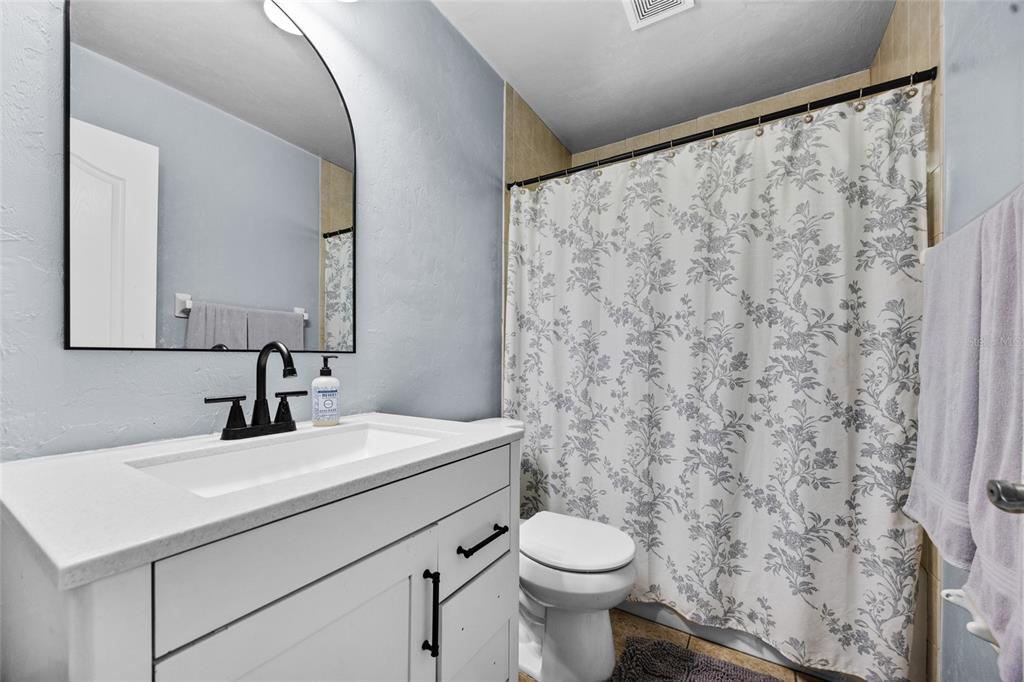 470 Margaret Street Bronson, FL 32621 - Photo 16 of 22 a bathroom with a sink a toilet and a mirror