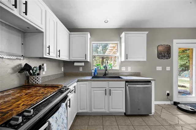 a kitchen with cabinets appliances and a window