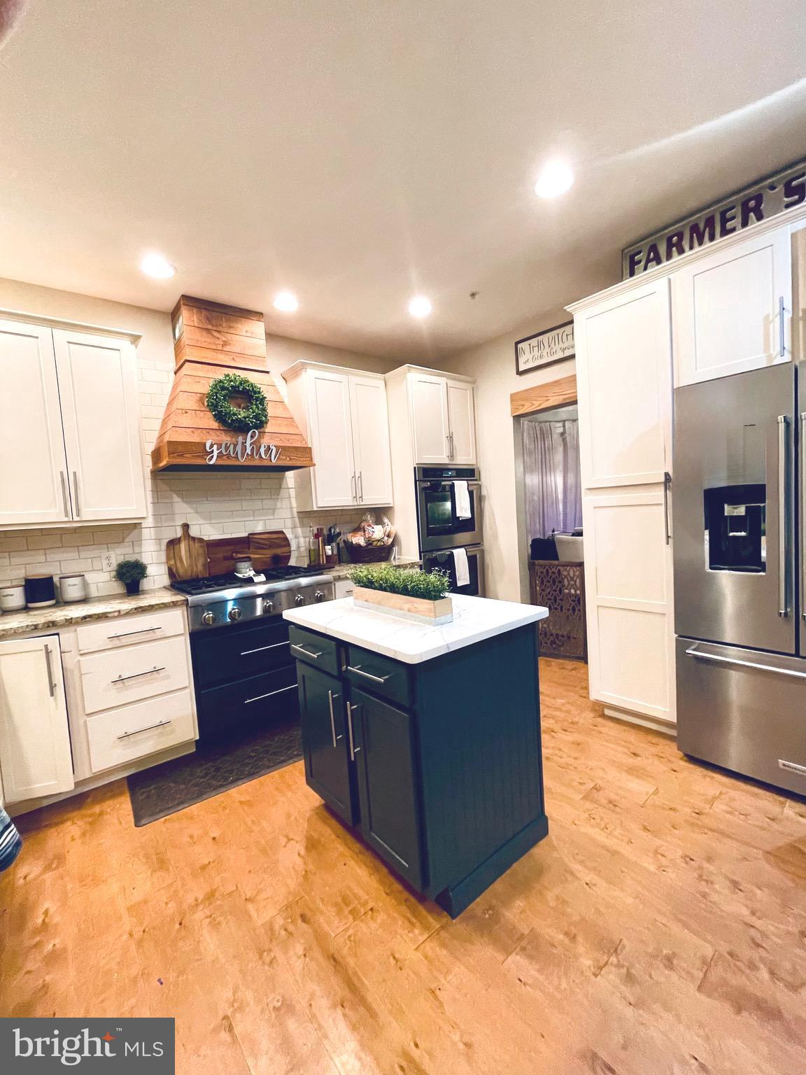 639 Old Orchard Road Bel Air, MD 21014 - Photo 9 of 46 a kitchen with stainless steel appliances granite countertop a stove top oven a refrigerator a sink and dishwasher with wooden floor