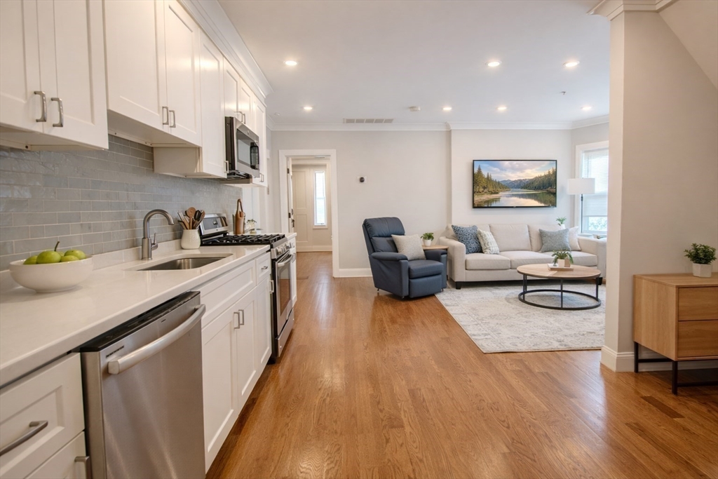 53 Quint Avenue, Unit 3 Boston, MA 02134 - Photo 10 of 18 a kitchen with sink cabinets and wooden floor
