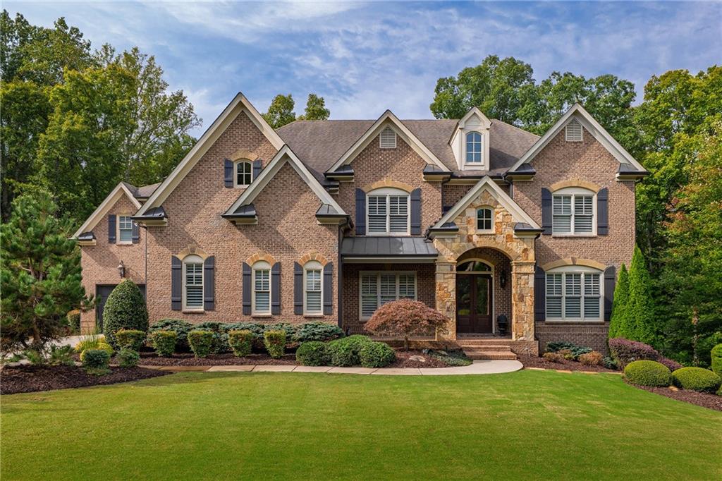 16750 Quayside Drive Milton, GA 30004 - Photo 1 of 53 a front view of a house with a yard and garage