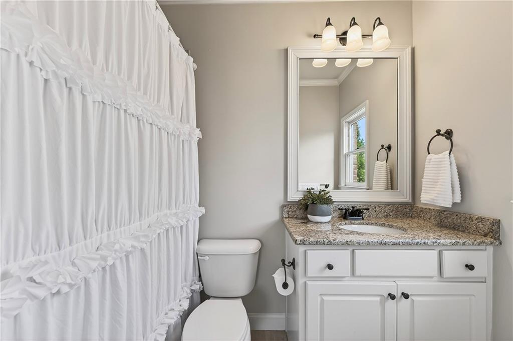 16750 Quayside Drive Milton, GA 30004 - Photo 30 of 53 a bathroom with a granite countertop sink vanity mirror and toilet