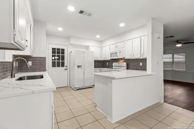 a kitchen with stainless steel appliances a refrigerator sink stove microwave and cabinets