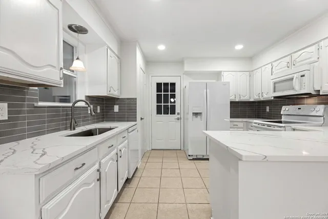 a kitchen with stainless steel appliances a stove sink microwave and cabinets
