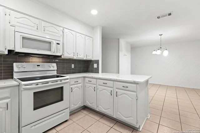 a kitchen with white cabinets stainless steel appliances and sink