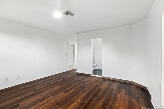 a view of an empty room with wooden floor