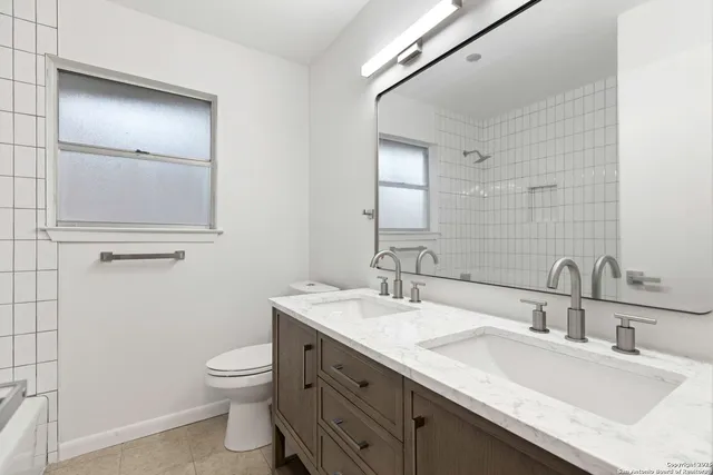 a bathroom with a sink toilet and mirror