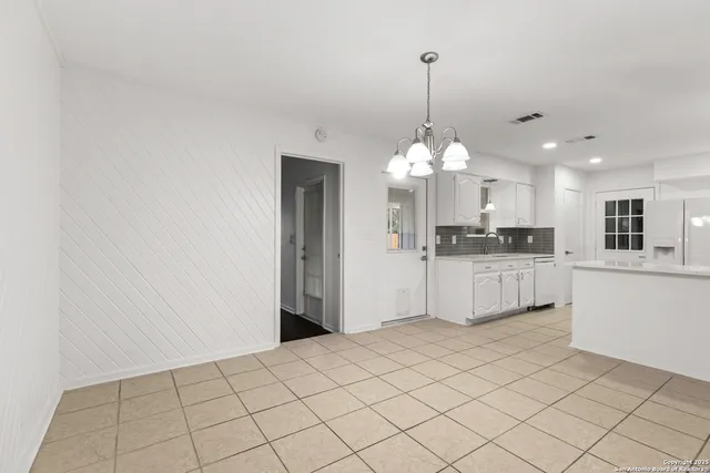 a kitchen with white cabinets and white appliances