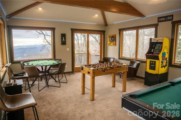 a room with pool table two windows and outdoor view