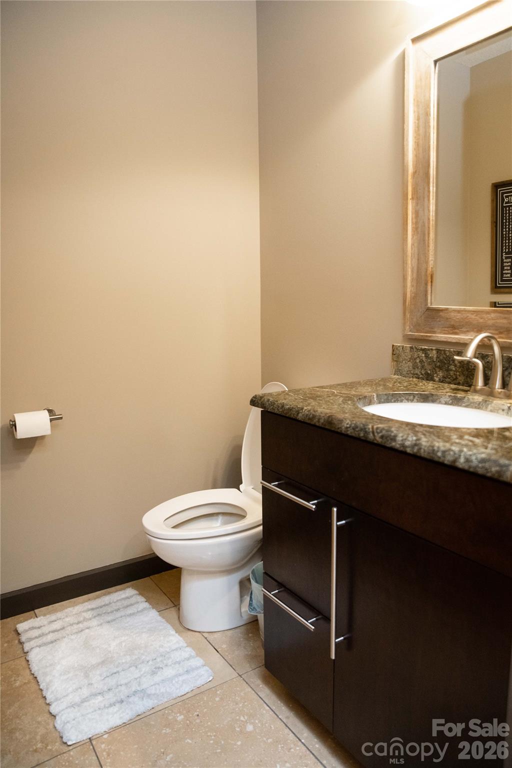 425 Flat Top Mountain Road Fairview, NC 28730 - Photo 28 of 48 a bathroom with a granite countertop sink and a toilet