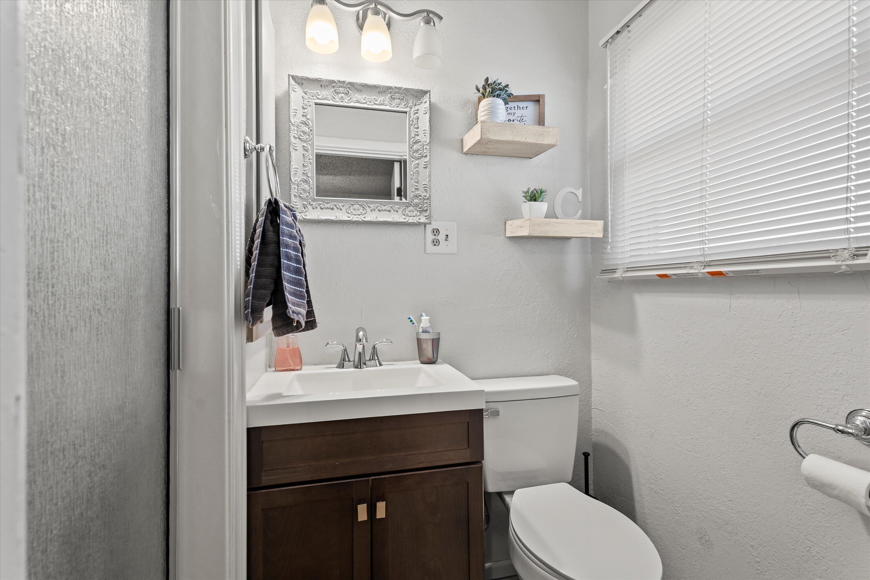 804 2nd Street Plains, TX 79355 - Photo 7 of 18 a bathroom with a sink toilet and mirror