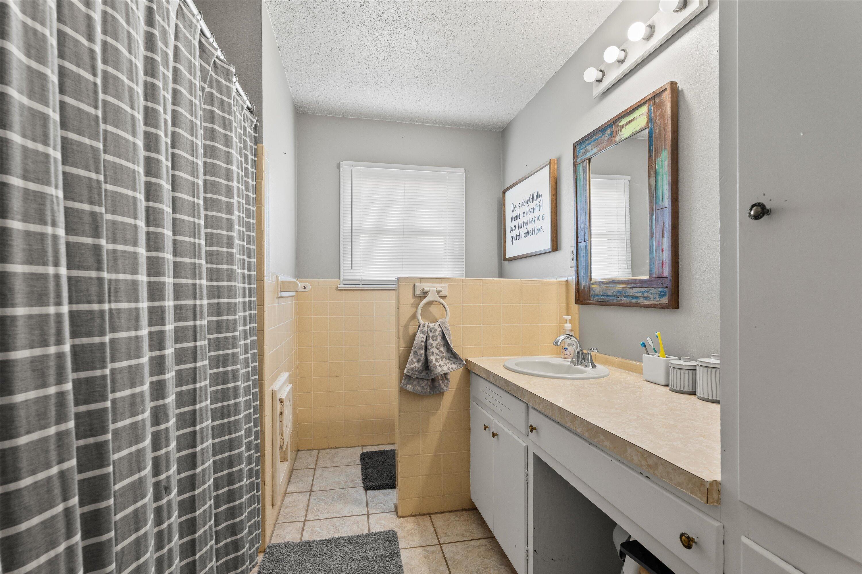 804 2nd Street Plains, TX 79355 - Photo 9 of 18 a bathroom with a sink a vanity and a mirror