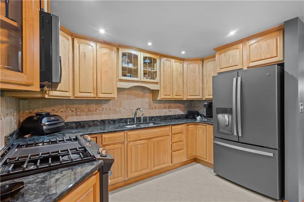 90 Davis Road Coraopolis, PA 15108 - Photo 8 of 29 a kitchen with granite countertop stainless steel appliances a stove a sink a refrigerator cabinets and a window