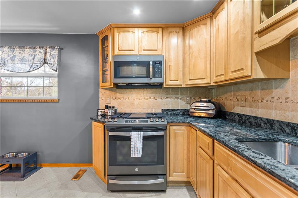 90 Davis Road Coraopolis, PA 15108 - Photo 9 of 29 a kitchen with stainless steel appliances granite countertop a stove a sink and a microwave
