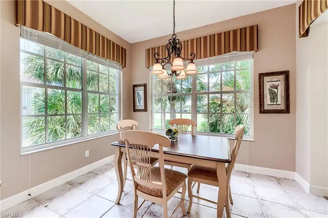 a dining room with furniture a chandelier and wooden floor